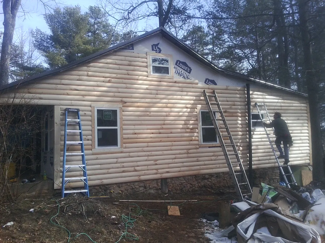 Ladders set against fresh log siding during an exterior remodel in Doylestown