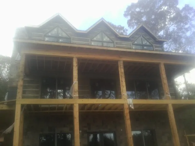 Dormers and porch framing on a large log home under construction — Roof Coating work by our crew in Doylestown
