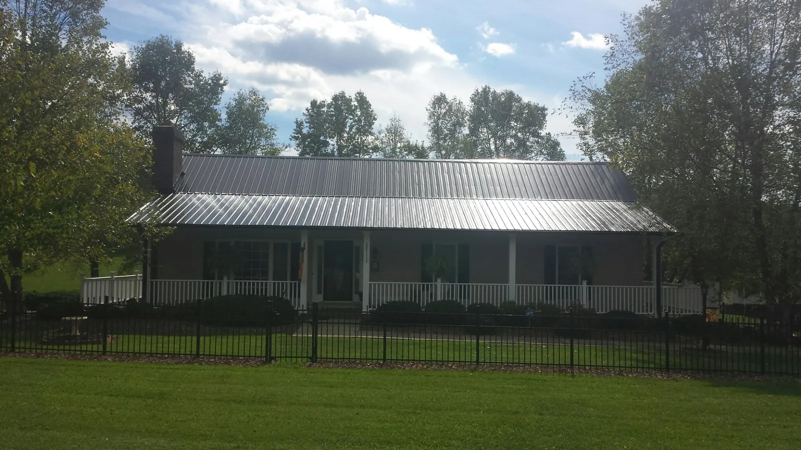 Gray metal roof on a brick ranch with a full width front porch — Gutter Guard Installation work by our crew in Doylestown